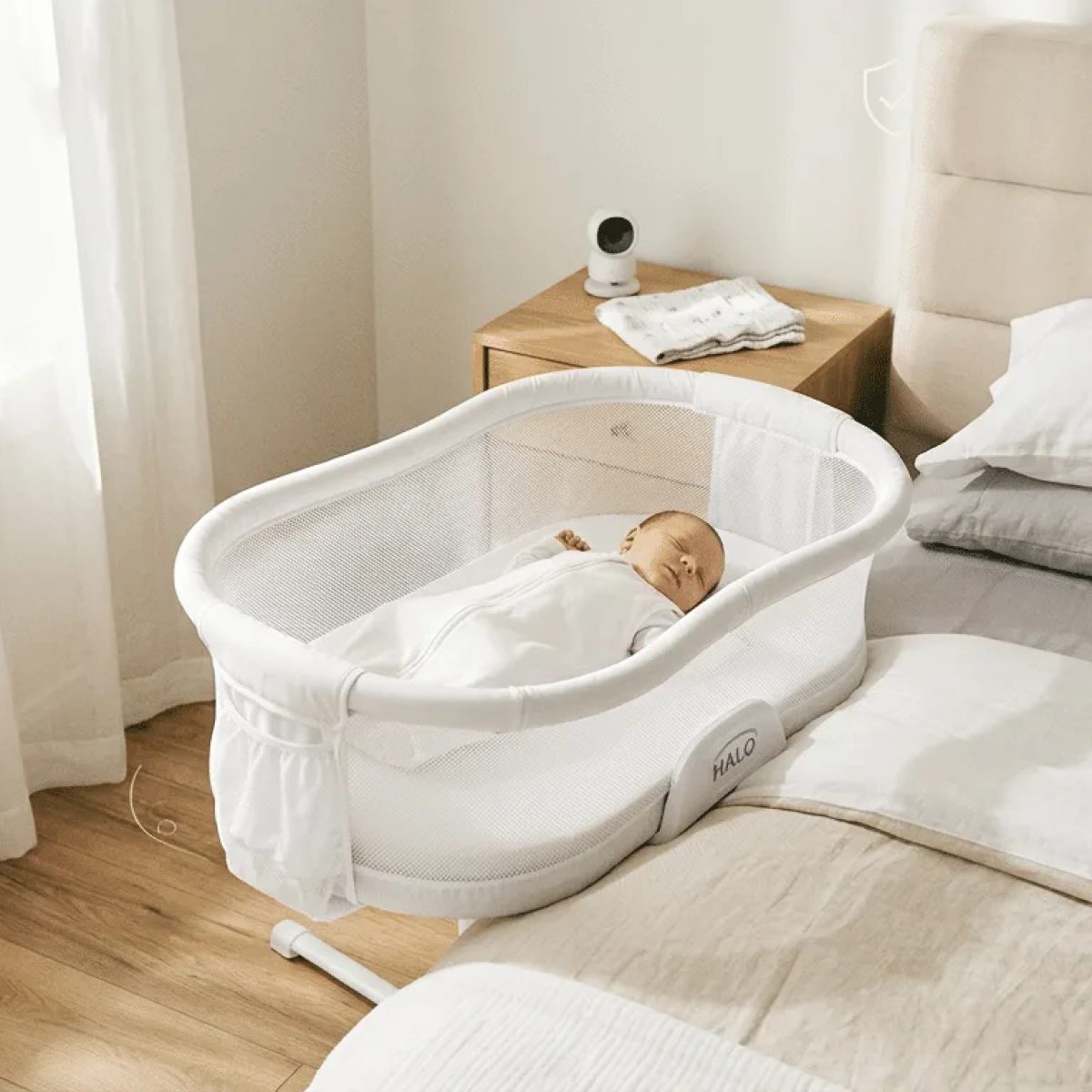 Halo BassiNest Swivel Sleeper bedside bassinet with a baby